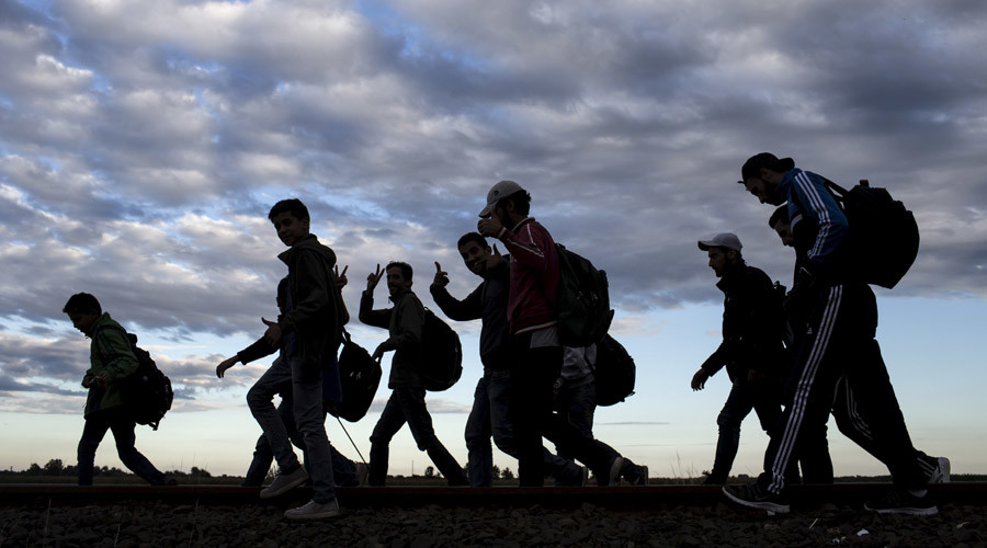 Migrants walk along rail tracks as they arrive to a collection point in the village of Roszke in Hungary after crossing the border from Serbia, September 6, 2015, . Thousands of refugees and migrants streamed into Germany on Sunday, many traveling through Austria from Hungary where they had been stranded against their will for days, while European Union governments argue over how to respond. REUTERS/Marko Djurica - RTX1RCY9